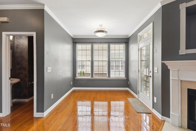5503 Silver Moon Ln, Raleigh, NC 27606 - unfurnished dining area featuring wood finished floors, a fireplace, and ornamental molding