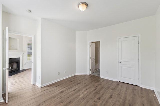 15 Canary Ct, Durham, NC 27713 - unfurnished bedroom featuring wood finished floors, a fireplace with flush hearth, and connected bathroom