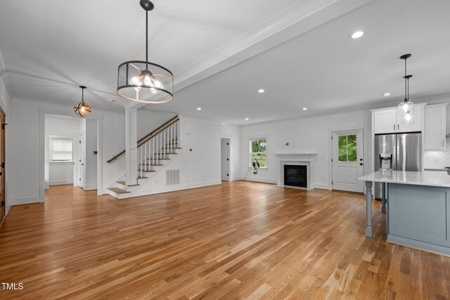 2551 Drake Ave, Durham, NC 27705 - unfurnished living room with stairs, recessed lighting, light wood-style flooring, and a fireplace