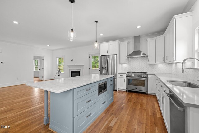 2551 Drake Ave, Durham, NC 27705 - kitchen with stainless steel appliances, wall chimney range hood, open floor plan, white cabinetry, and tasteful backsplash
