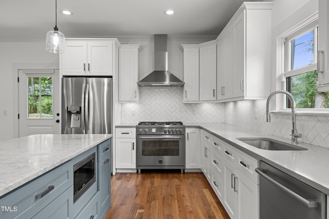 2551 Drake Ave, Durham, NC 27705 - kitchen featuring wall chimney range hood, stainless steel appliances, plenty of natural light, white cabinetry, and recessed lighting