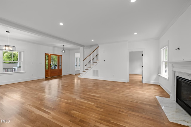 2551 Drake Ave, Durham, NC 27705 - unfurnished living room with a premium fireplace, light wood finished floors, recessed lighting, stairs, and a chandelier