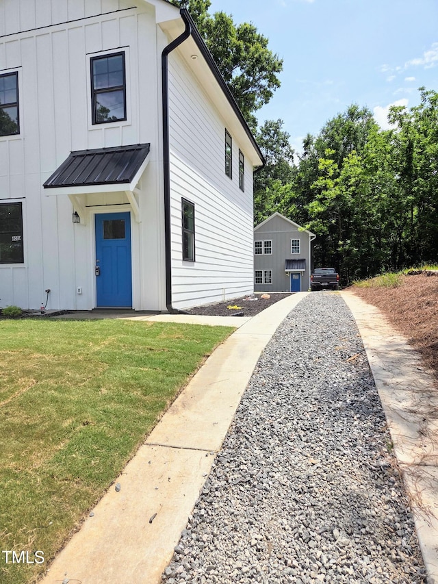 608A E Umstead, Durham, NC 27701 - view of front of home with board and batten siding, a front lawn, and a metal roof