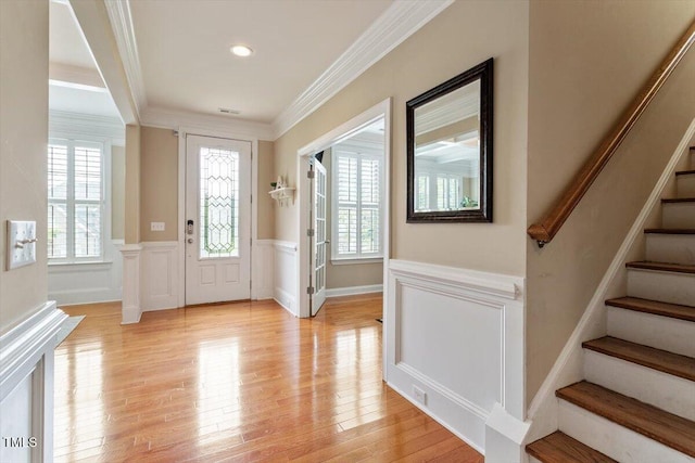 150 Saint Mellion St, Raleigh, NC 27603 - entryway with stairway, a wainscoted wall, ornamental molding, light wood-style flooring, and a decorative wall
