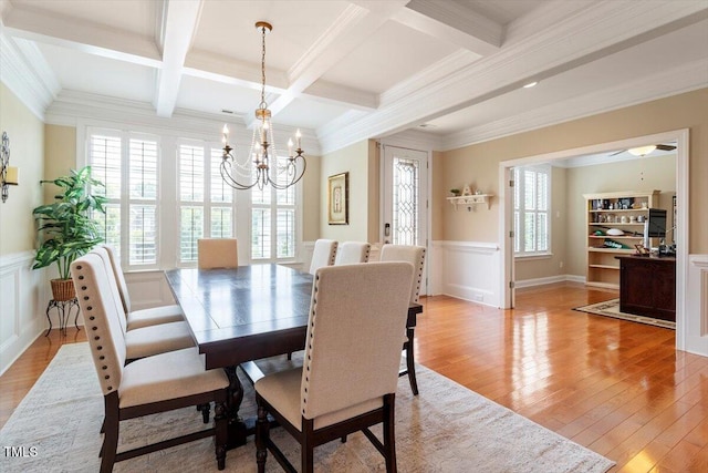 150 Saint Mellion St, Raleigh, NC 27603 - dining space featuring a chandelier, beam ceiling, a wainscoted wall, light wood-style floors, and a decorative wall