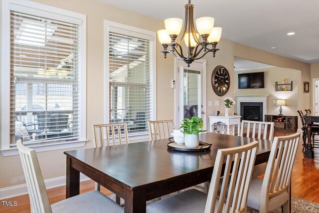 150 Saint Mellion St, Raleigh, NC 27603 - dining space with wood finished floors, a chandelier, a fireplace, and recessed lighting