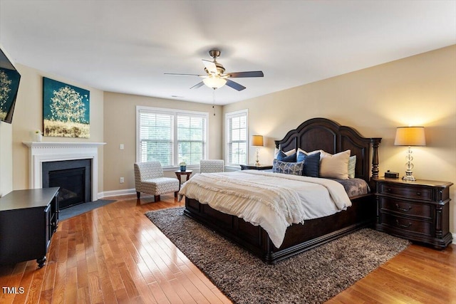 150 Saint Mellion St, Raleigh, NC 27603 - bedroom featuring wood finished floors, a fireplace with flush hearth, and ceiling fan