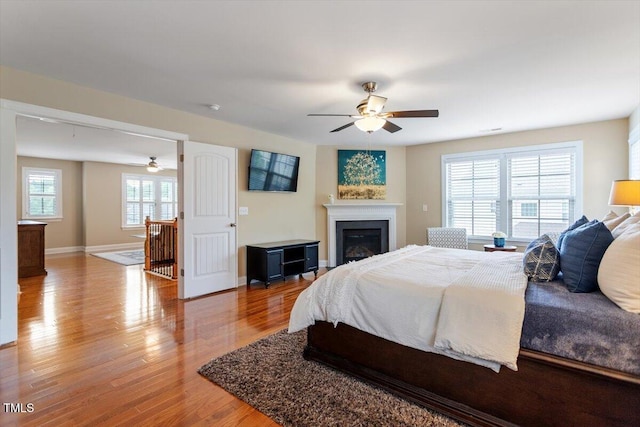 150 Saint Mellion St, Raleigh, NC 27603 - bedroom featuring wood finished floors, a glass covered fireplace, and a ceiling fan