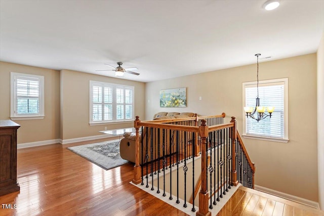 150 Saint Mellion St, Raleigh, NC 27603 - stairs with plenty of natural light, a chandelier, wood finished floors, and ceiling fan