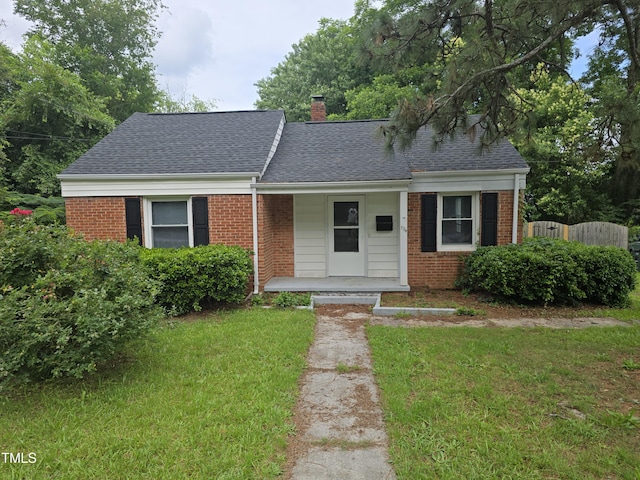 704 N King Charles Rd, Raleigh, NC 27610 - view of front of house featuring brick siding, a porch, roof with shingles, and a chimney