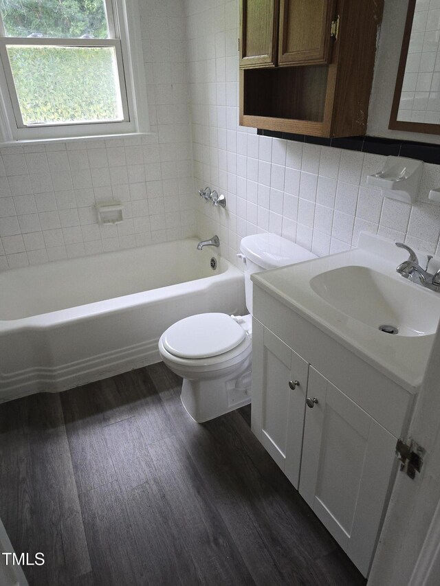 704 N King Charles Rd, Raleigh, NC 27610 - bathroom featuring tile walls, wood finished floors, vanity, and decorative backsplash