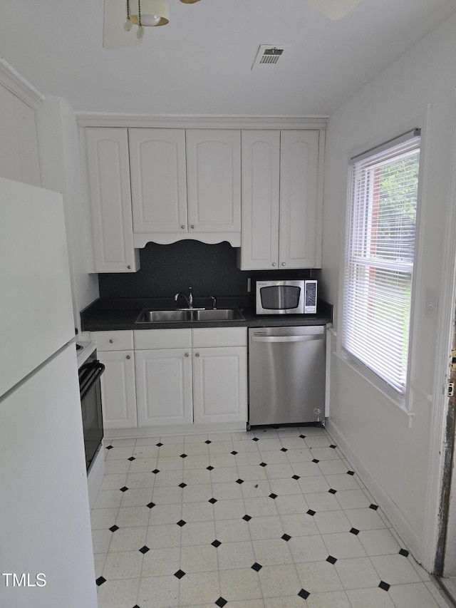 704 N King Charles Rd, Raleigh, NC 27610 - kitchen featuring appliances with stainless steel finishes, dark countertops, and white cabinets
