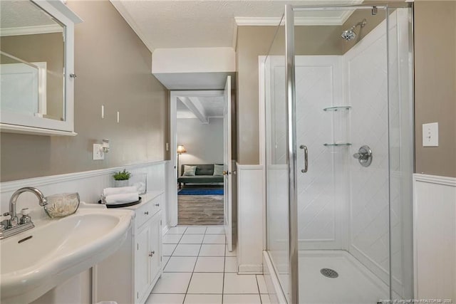 140 Bledsoe St, Hope Mills, NC 28348 - bathroom with a shower stall, wainscoting, tile patterned flooring, a decorative wall, and a textured ceiling