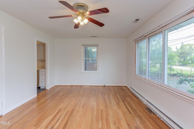 2009 Carolina Ave, Durham, NC 27705 - unfurnished room featuring a baseboard heating unit, light wood finished floors, and a ceiling fan