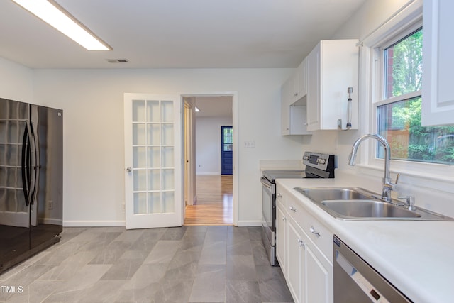 2009 Carolina Ave, Durham, NC 27705 - kitchen with stainless steel appliances, white cabinetry, and light countertops