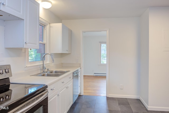 2009 Carolina Ave, Durham, NC 27705 - kitchen with appliances with stainless steel finishes, white cabinetry, light countertops, and a baseboard heating unit