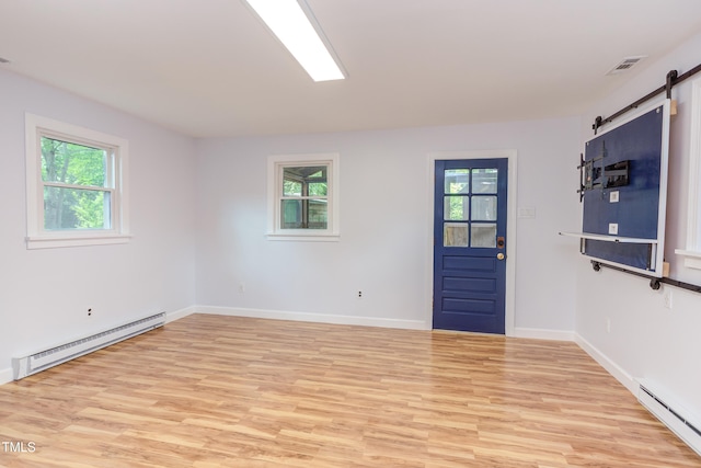 2009 Carolina Ave, Durham, NC 27705 - unfurnished room with baseboard heating, a barn door, light wood-type flooring, and plenty of natural light