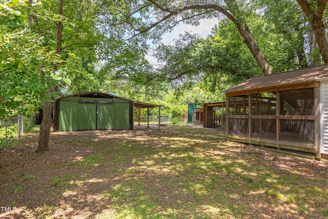 2009 Carolina Ave, Durham, NC 27705 - view of yard featuring a carport, a sunroom, a storage unit, and view of scattered trees