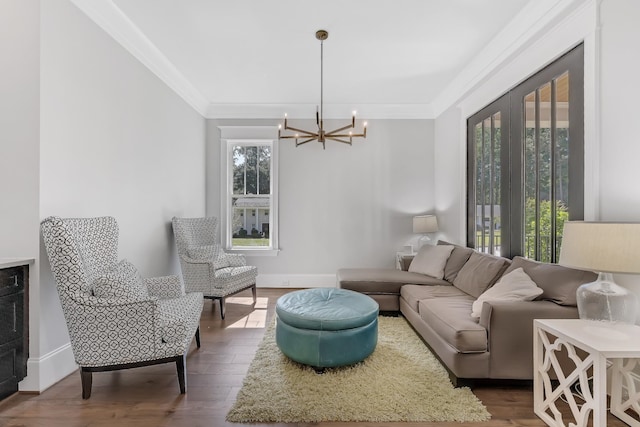6900 Staghorn Ln, Raleigh, NC 27615 - living room featuring a chandelier, wood finished floors, and crown molding