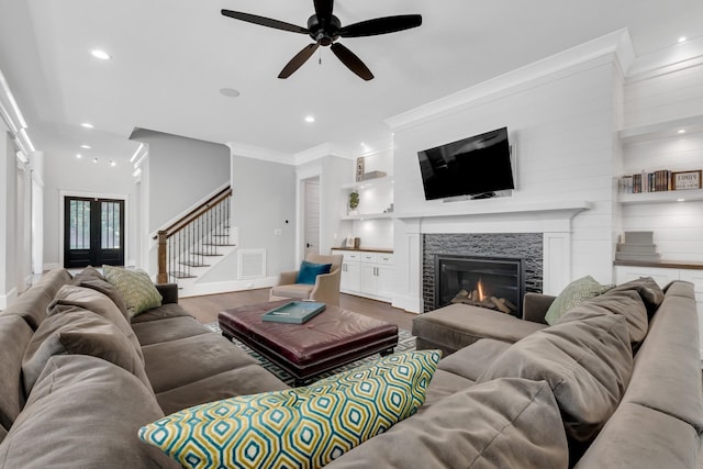 6900 Staghorn Ln, Raleigh, NC 27615 - living area with dark wood-style flooring, stairs, ceiling fan, a glass covered fireplace, and ornamental molding