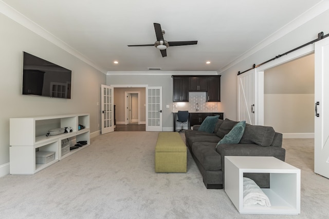 6900 Staghorn Ln, Raleigh, NC 27615 - living area featuring a barn door, ornamental molding, carpet floors, french doors, and a ceiling fan