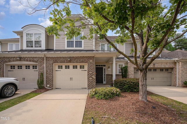 1016 Kingston Grove Dr, Cary, NC 27519 - view of property with brick siding, driveway, an attached garage, a standing seam roof, and a metal roof