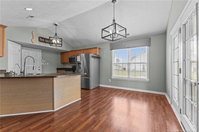 2720 Daniel Boone Ln, Hope Mills, NC 28348 - kitchen with a chandelier, appliances with stainless steel finishes, dark countertops, vaulted ceiling, and a peninsula