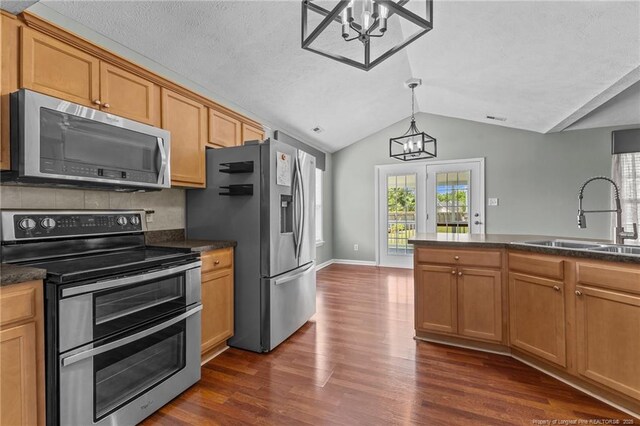 2720 Daniel Boone Ln, Hope Mills, NC 28348 - kitchen featuring appliances with stainless steel finishes, a chandelier, lofted ceiling, and dark countertops