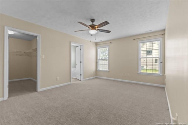 2720 Daniel Boone Ln, Hope Mills, NC 28348 - unfurnished bedroom with carpet floors, a walk in closet, ensuite bath, and ceiling fan