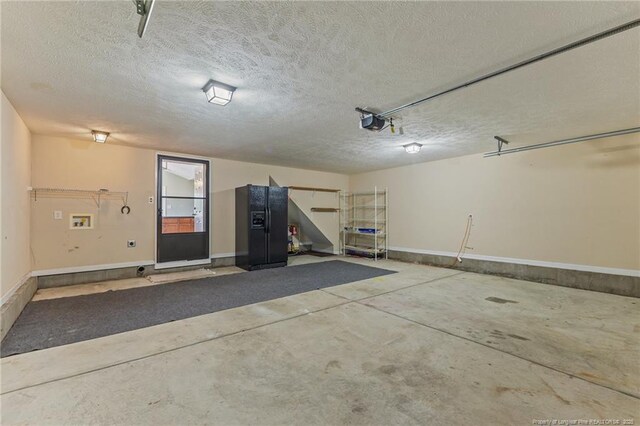 2720 Daniel Boone Ln, Hope Mills, NC 28348 - garage with a garage door opener and black fridge with ice dispenser