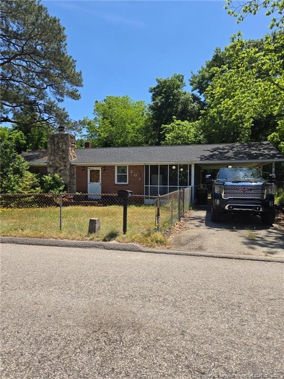 201 Scarborough St, Spring Lake, NC 28390 - view of front facade featuring asphalt driveway, a chimney, a fenced front yard, and brick siding