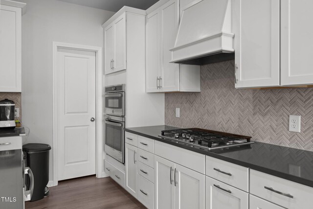 2346 Mckenzie Ridge Ln, Apex, NC 27502 - kitchen featuring custom exhaust hood, stainless steel appliances, backsplash, and dark countertops