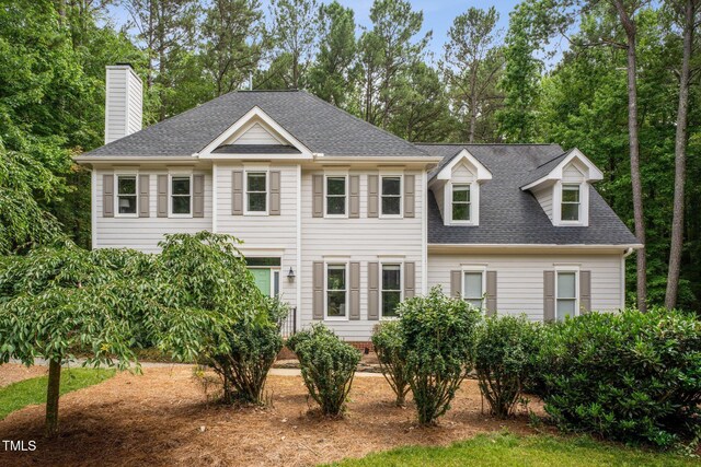 5809 N Hawthorne Way, Raleigh, NC 27603 - view of front facade featuring roof with shingles, a chimney, and view of scattered trees
