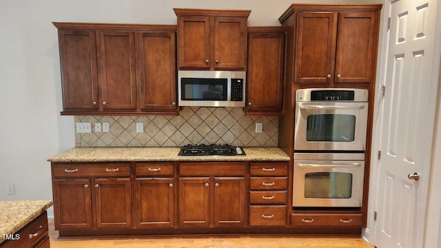 1016 Dotson Way, Apex, NC 27523 - kitchen featuring appliances with stainless steel finishes, tasteful backsplash, and light stone counters