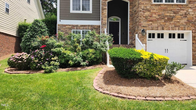1016 Dotson Way, Apex, NC 27523 - doorway to property with stone siding, a garage, a lawn, and concrete driveway