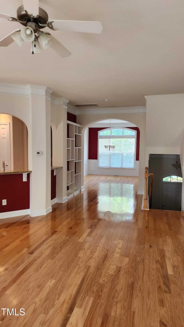1016 Dotson Way, Apex, NC 27523 - unfurnished living room with ornamental molding, a ceiling fan, arched walkways, light wood-type flooring, and built in features