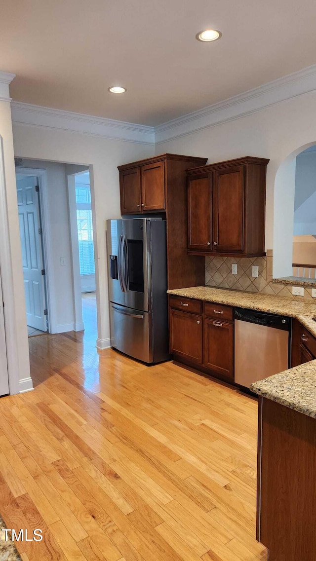 1016 Dotson Way, Apex, NC 27523 - kitchen with stainless steel appliances, arched walkways, ornamental molding, backsplash, and light wood-style flooring