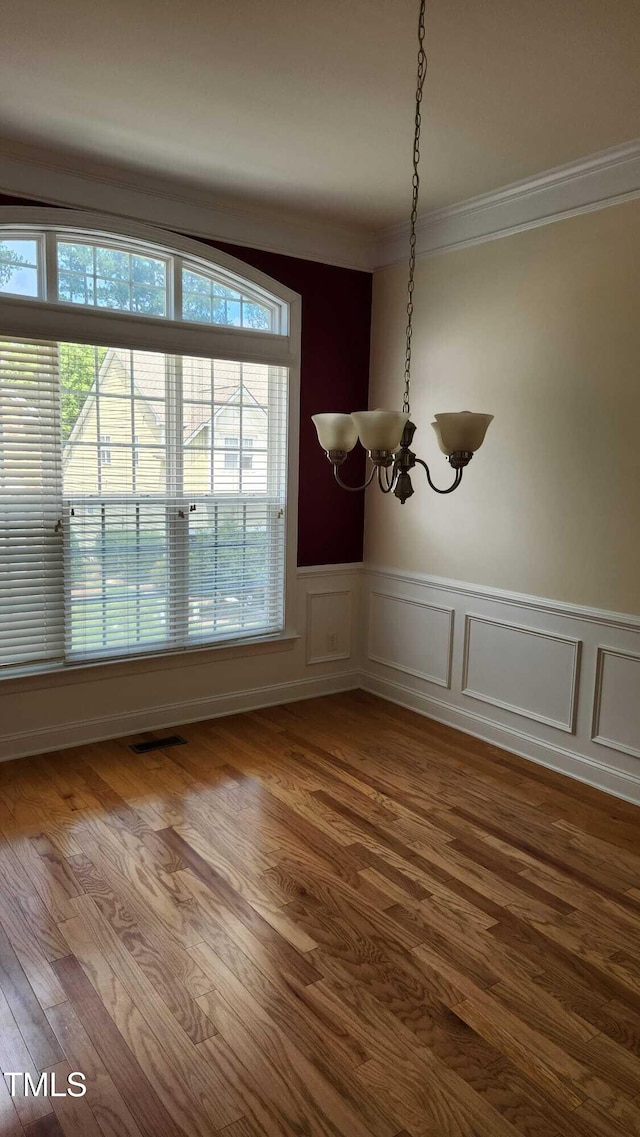 1016 Dotson Way, Apex, NC 27523 - unfurnished dining area featuring a chandelier, ornamental molding, a wainscoted wall, and dark wood-style floors