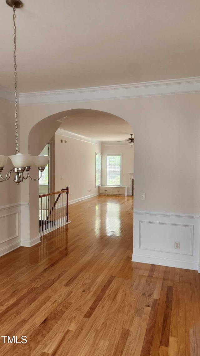 1016 Dotson Way, Apex, NC 27523 - unfurnished room featuring arched walkways, ornamental molding, a chandelier, light wood-style flooring, and a wainscoted wall