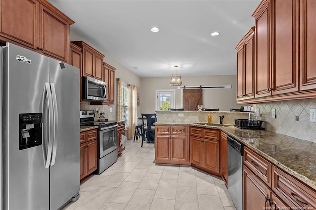 5135 Paul Peel Pl, Hope Mills, NC 28348 - kitchen with stainless steel appliances, a peninsula, decorative backsplash, recessed lighting, and brown cabinets