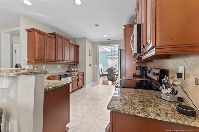 5135 Paul Peel Pl, Hope Mills, NC 28348 - kitchen with stainless steel appliances, tasteful backsplash, brown cabinetry, light stone countertops, and recessed lighting