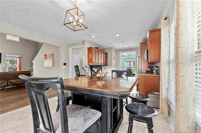 5135 Paul Peel Pl, Hope Mills, NC 28348 - kitchen with a chandelier, stainless steel microwave, brown cabinets, recessed lighting, and light tile patterned flooring