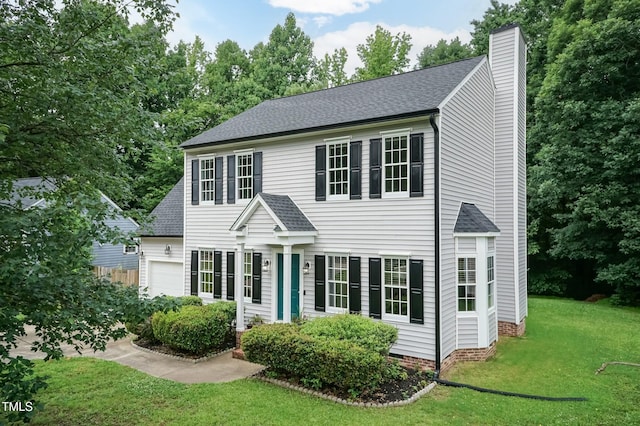 3110 Trinness Dr, Durham, NC 27707 - colonial-style house featuring a chimney, a front yard, roof with shingles, and an attached garage