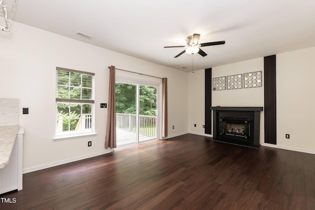 3110 Trinness Dr, Durham, NC 27707 - unfurnished living room with ceiling fan, dark wood-style floors, and a fireplace with raised hearth