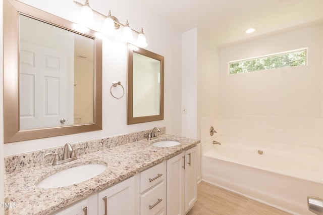 3110 Trinness Dr, Durham, NC 27707 - bathroom with double vanity, a bath, and wood finished floors
