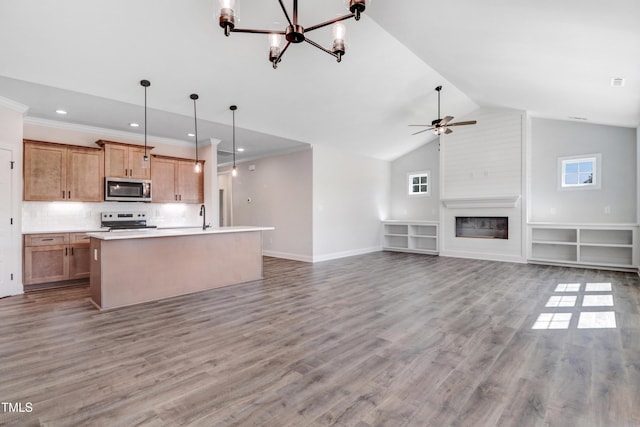 222 Cherrybirch Ln, Zebulon, NC 27597 - kitchen with stainless steel microwave, range with electric stovetop, a chandelier, open floor plan, and a kitchen island with sink