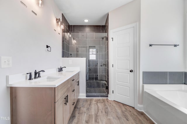 222 Cherrybirch Ln, Zebulon, NC 27597 - bathroom featuring a stall shower, double vanity, a garden tub, and wood finished floors