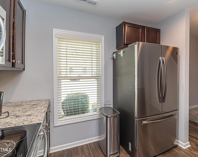 121 Longleaf Pine St, Clayton, NC 27527 - kitchen with freestanding refrigerator, dark wood-type flooring, dark brown cabinets, and light stone countertops