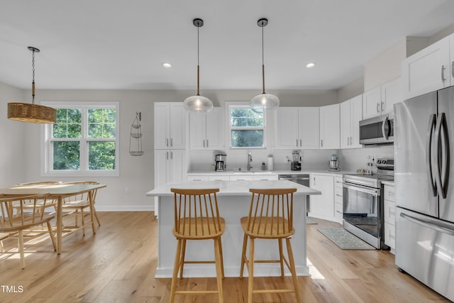 3909 Bristlewood Dr, Durham, NC 27703 - kitchen with stainless steel appliances, a center island, light wood-type flooring, light countertops, and recessed lighting