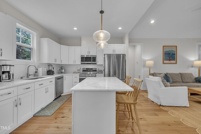3909 Bristlewood Dr, Durham, NC 27703 - kitchen with appliances with stainless steel finishes, a kitchen breakfast bar, tasteful backsplash, open floor plan, and recessed lighting